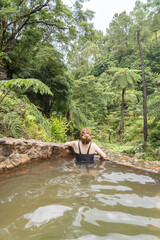 Fototapeta premium Woman in the hot springs of Caldeira Velha in Sao Miguel island of the Azores.