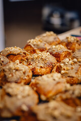 close up of batch of delicious fresh iced nutty pastries in professional bakery kitchen 