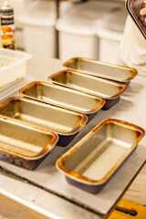 rustic loaf tins lined up in professional bakery kitchen
