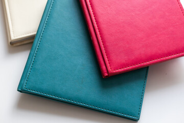 on a wooden table and a beige wall there are unfolded and closed white books