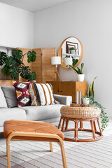 Interior of light living room with sofa, table and Monstera houseplant