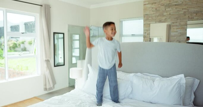 Fun, happiness and child jumping on bed with playful energy, freedom and excited in morning at home. Smile, holiday and happy kid in bedroom, weekend celebration and boy playing game in apartment.