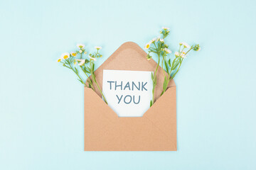 Thank you card in an envelope surrounded by flowers, being thankful, support, help and charity...