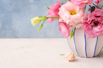 Vase with beautiful pink eustoma flowers on white table