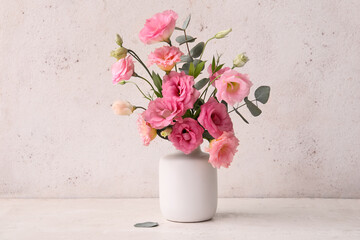 Vase with beautiful pink eustoma flowers and eucalyptus on white background
