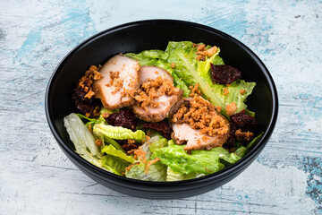 Salad with chicken fillet, sun-dried tomatoes, crispy fried onions and lettuce.