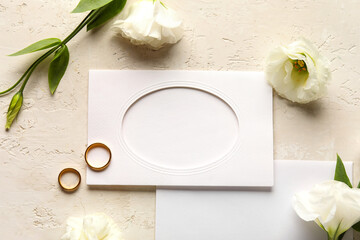 Fototapeta na wymiar Composition with blank cards, wedding rings and beautiful eustoma flowers on light background, closeup