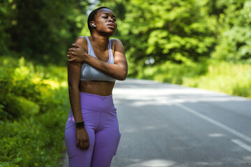 Shot of a young woman holding her arm in pain while exercising.