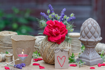 romantisches Arrangement mit Blumenstrauß mit roter Rose und Lavendel-Blüten, Tischlaterne und...