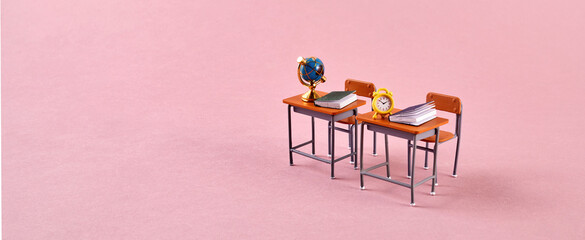 School desk with school accessory on pink background