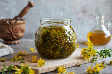 Macerating fresh St. John's wort blossoms in oil to prepare herbal remedy