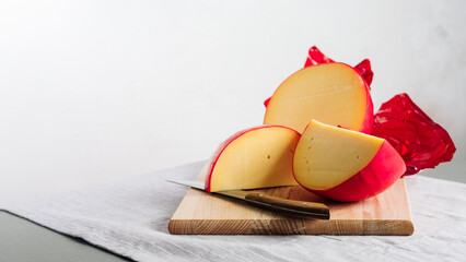 Sliced head of Edam cheese. - obrazy, fototapety, plakaty