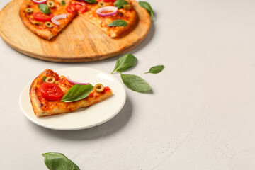 Board and plate with tasty pizza on grey background