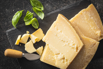 Tasty parmesan cheese on cutting board. Top view. - obrazy, fototapety, plakaty