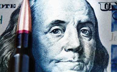 Close up of bullets against US Dollar bill as an abstract symbol of business is in the blood