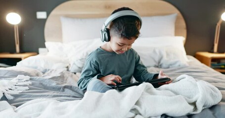 Boy, child and tablet with headphones in bedroom at night for online games, streaming movies and play educational app. Happy kid, digital technology and listening to media, watching cartoon and music