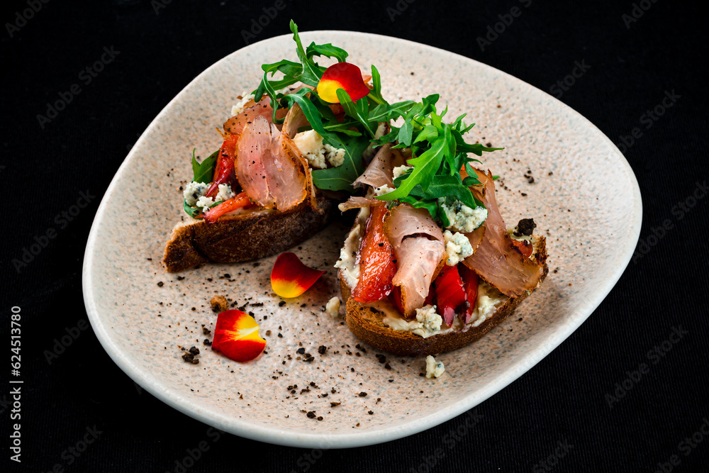 Wall mural Bruschettas with bacon, sweet pepper, blue cheese and arugula, restaurant menu.