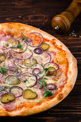 Pizza with ham, cheese, red onion, pickles and microgreens, Italian cuisine.