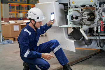 Engineers inspecting locomotive in railway engineering facility