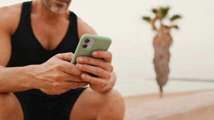 Close-up of male hands using mobile phone