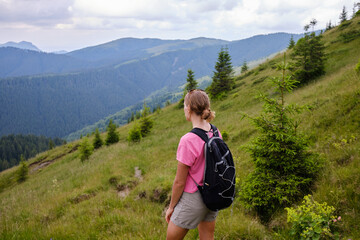 Girl is watching on mountains view. Woman is hiking in mountains in summer.Beautiful mountain...