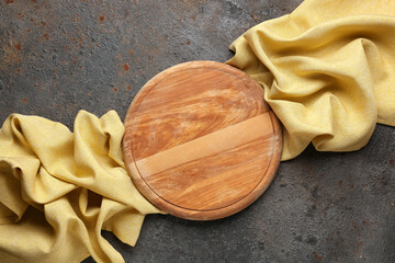 Wooden kitchen board and clean napkin on grunge background