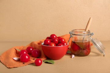Bowl and jar with canned tomatoes on brown background