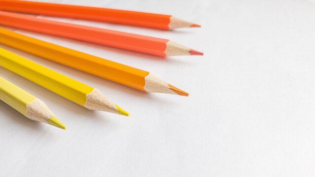 Yellow and orange pencils on light background. Child drawing concept. Art background with copy space