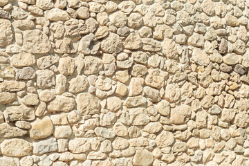 beige stone background texture of a wall on a sunny day