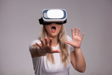 Amazed young woman in virtual reality, using vr glasses headset