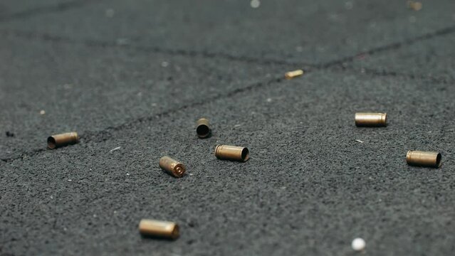 Empty bullets fall on the floor on shooting range. Sport shooter police training.