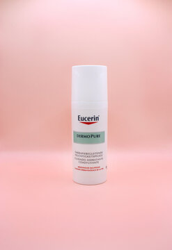 KYIV, UKRAINE - 1 JULY 2023: White Germany brand Eucerin cosmetics bottle. Eucerin DermoPure Skin Adjunctive Soothing Cream. Skin care product for healthy skin. Isolated on pink background.