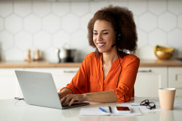 Smiling Black Lady With Laptop And Headset Working Remotely At Home