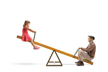 Grandfather playing on a seesaw with a little girl