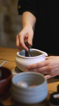 Matcha process of making green tea in a bowl on wooden table background