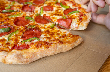 Pepperoni Pizza in Cardboard Delivery Box Closeup, Salami Pizza with Green Paprika, Chili Pepper