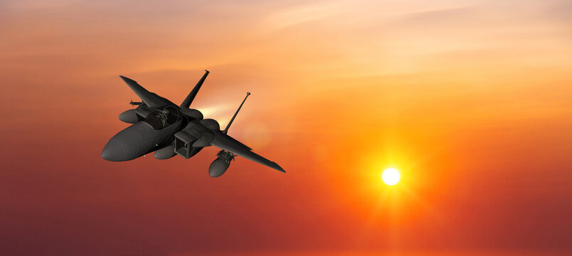 Military aircraft flying on a sunset sky background