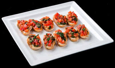 Bruschetta with with tomatoes and herbs in a white plate.