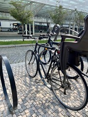 Obraz premium Bike for kids parked in a bike rack across the street. ecological mode of transport
