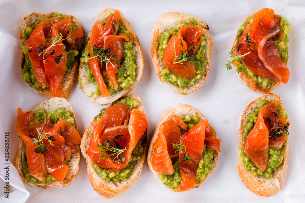 Canvas Prints Bruschetta with salmon, avocado and microgreens on a white.