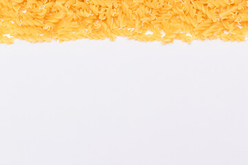 Uncooked Fusilli Pasta with Copy Space on White Background. Raw and Dry Macaroni. Fat and Unhealthy Food - Flat Lay