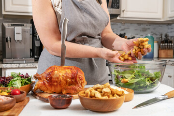 Cooking Caesar salad. A chef adds croutons to glass bowl in home kitchen.