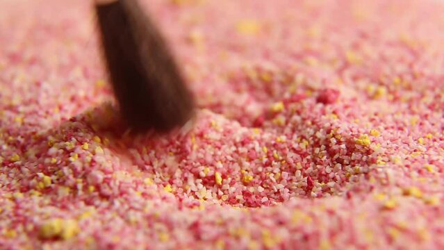 The colored granules are slowly stirred with a brush. asm video. Relaxing video.