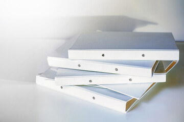Stack of white file folder or ring binder waiting to be processed in an office, administration and business work concept, copy space, selected focus