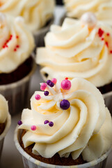 Cupcakes with whipped cream in a white plate, closeup.