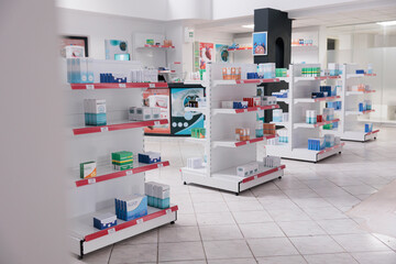 Empty pharmacy with nobody in it equipped with shelves full of pills packages and pharmaceutical products ready for customers. Drugstore filled with vitamins, health care support service and concept