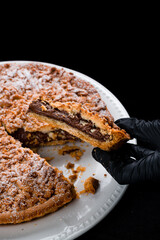 Piece of crumbly pie with chocolate and powdered sugar.