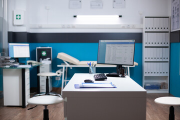 Empty healthcare medical interior, nobody inside modern clinic interior. Computer on desk with clinical examining diagnostic data, checking for disease in doctor medical space