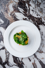 King prawns in cream sauce with oranges, spinach and microgreens.