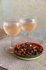 French cold rose dry wine from Provence in glass for lunch in restaurant with sweet pindas nuts,...